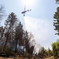 A helicopter drops water on a hot spot as a wildfire burns in Canada\'s Nova Scotia province on Thursday.  | NOVA SCOTIA GOVERNMENT / VIA AFP-JIJI