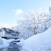 The TSUNAN SAKE BREWERY building surrounded by deep snow in Tsunan, Niigata, Japan, illustrating the heavy snow country terroir behind GO TERRACE.